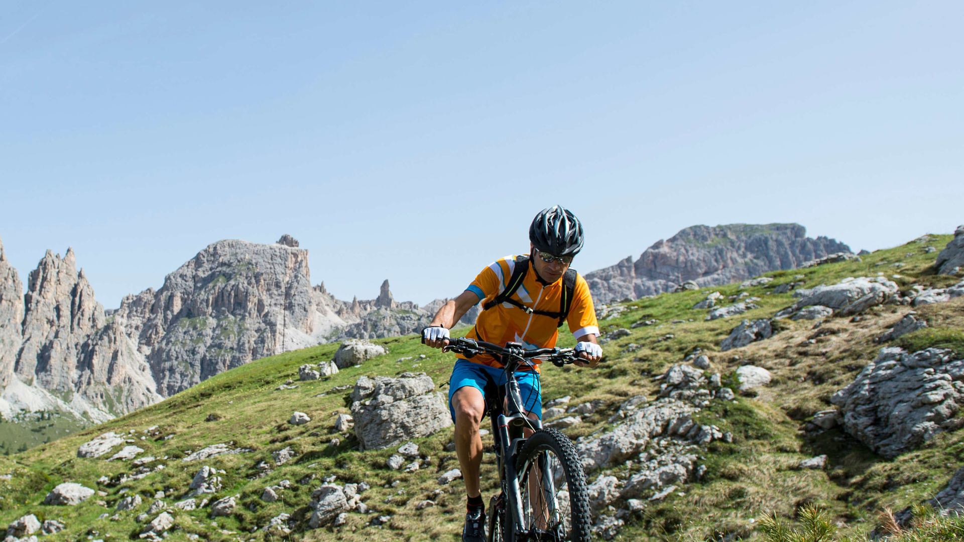 A Man Riding A Bike On A Trail In A Rocky Area