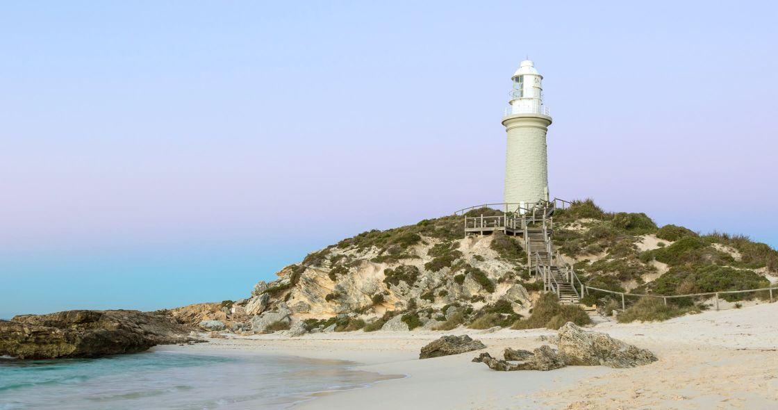 A Lighthouse On A Rocky Beach