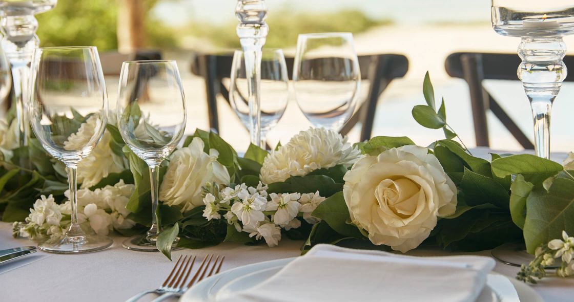 A Table With White Flowers And Glasses