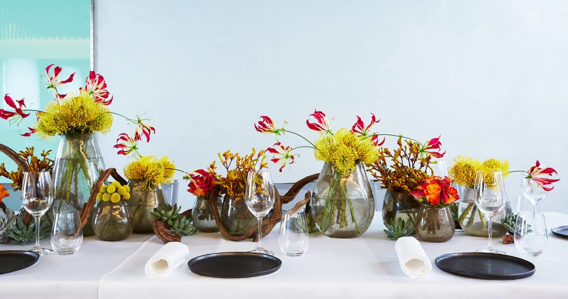 A Table Full Of Vases Of Flowers