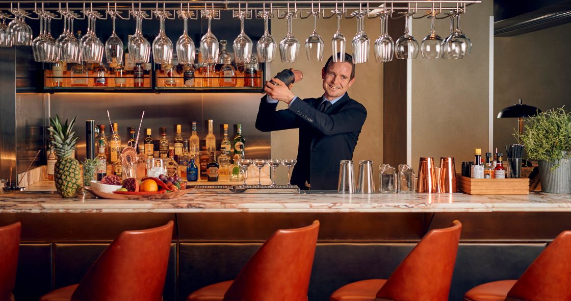 A Person Standing Behind A Bar