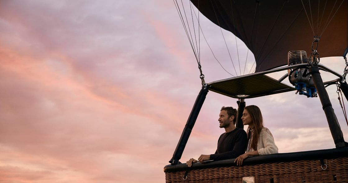 A Man And Woman Sitting On A Roof With A Satellite Dish