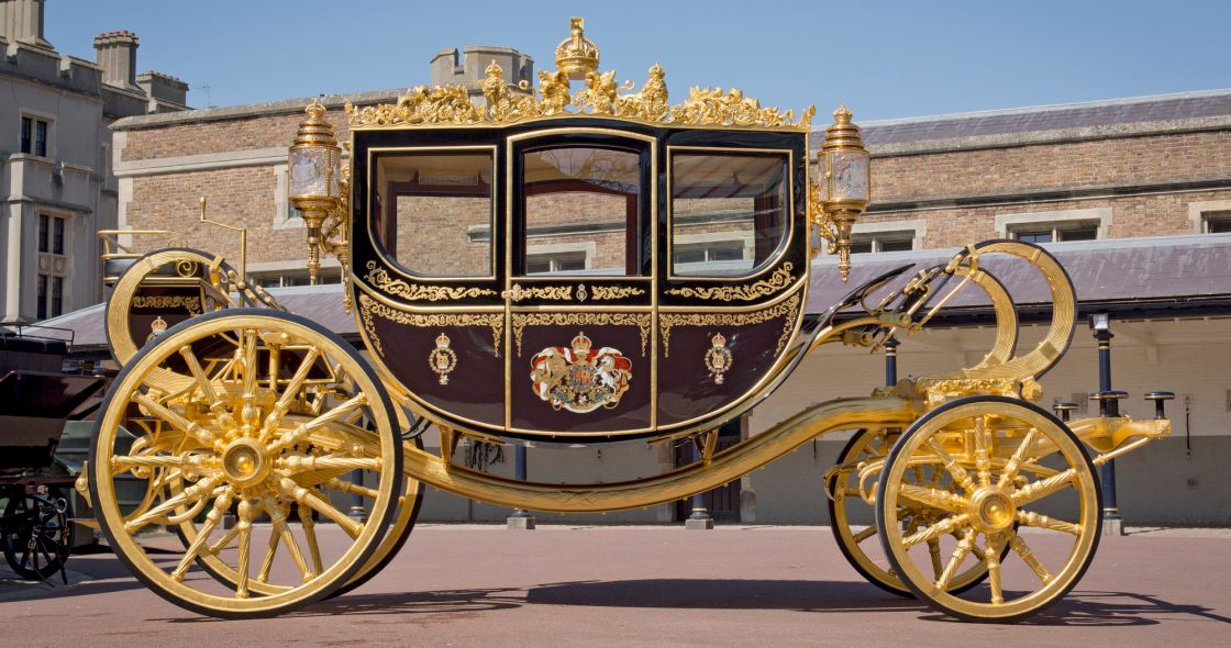 A Carriage With A Gold Top And Gold Wheels