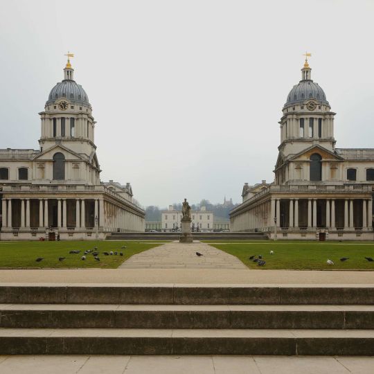 A Large Building With A Green Lawn With Greenwich In The Background
