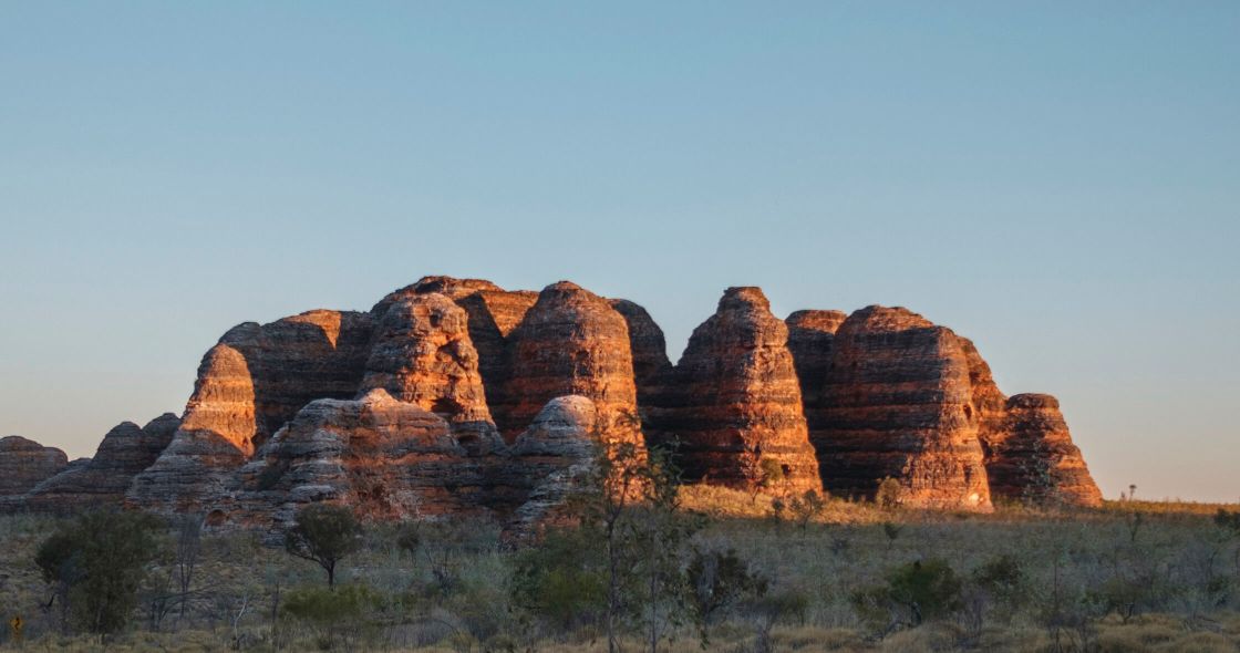 A Group Of Red Rock Formations With Cathedral Rock In The Background