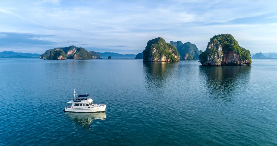 A Boat In The Water With Ha Long Bay In The Background