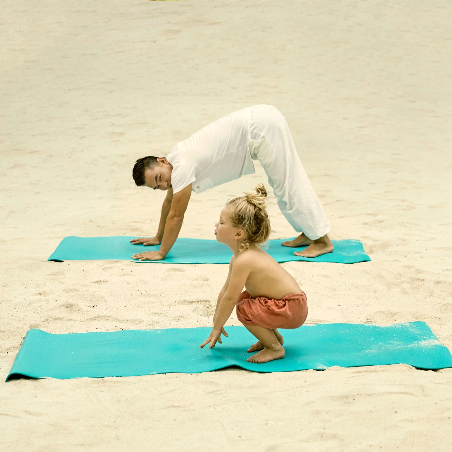 A Person And A Boy On A Mat On A Beach