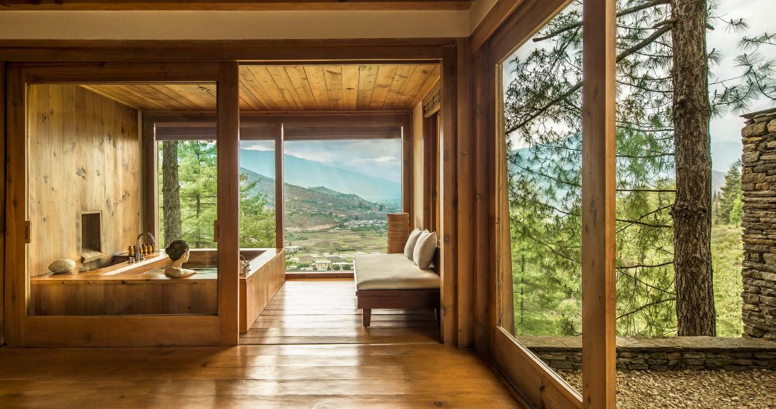 A Room With A Bed And A Window With Trees Outside