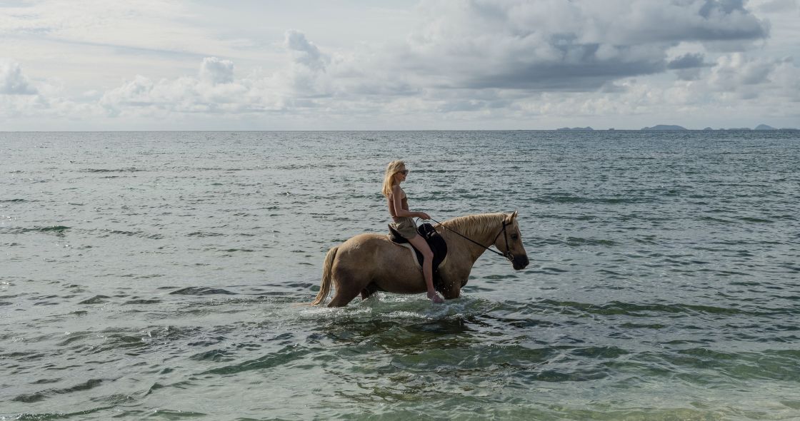 A Person Riding A Horse In The Ocean