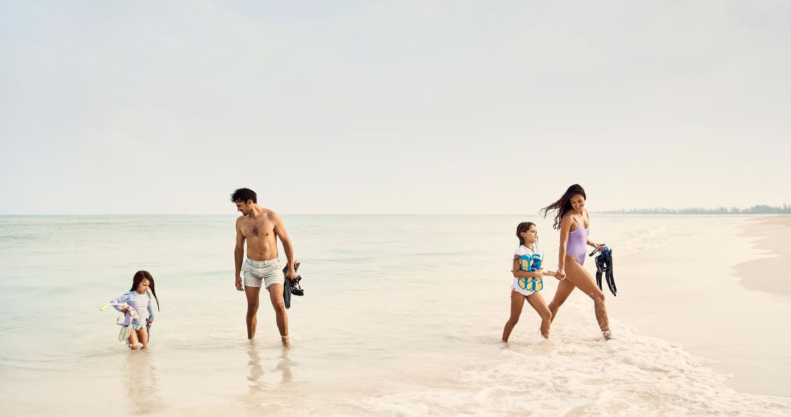 A Family Walking On The Beach