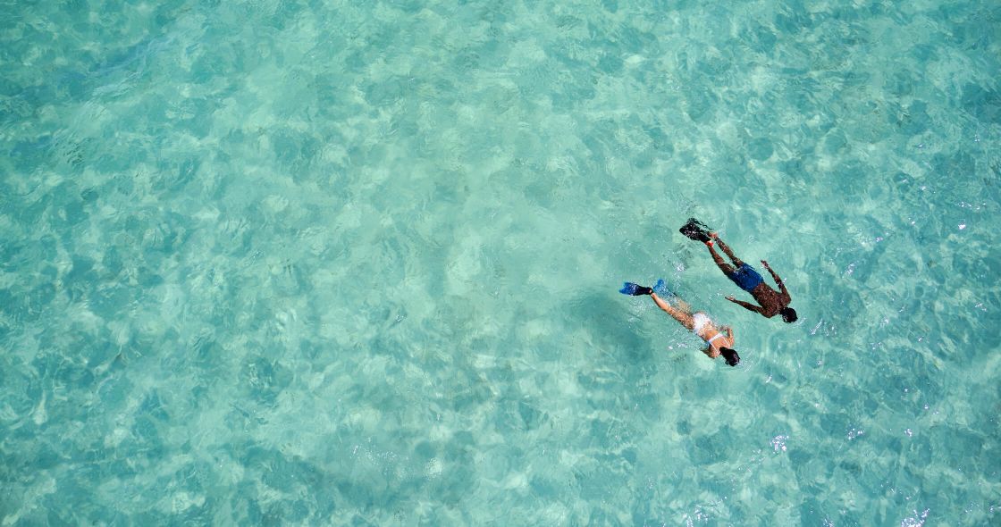 A Couple People Swimming In The Ocean