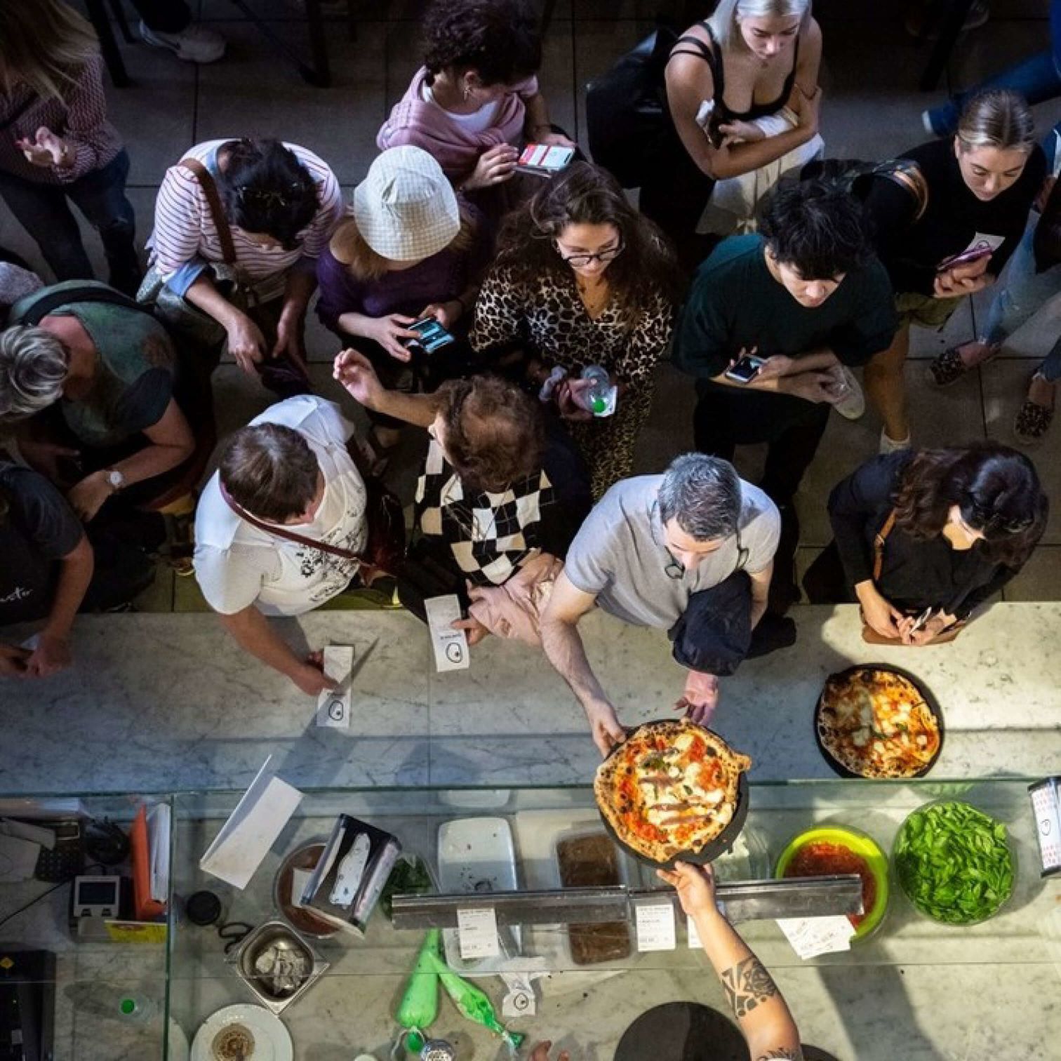 A Group Of People Kneeling On The Ground With Food On Them