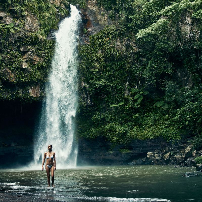 A Man Standing In Front Of A Waterfall Image