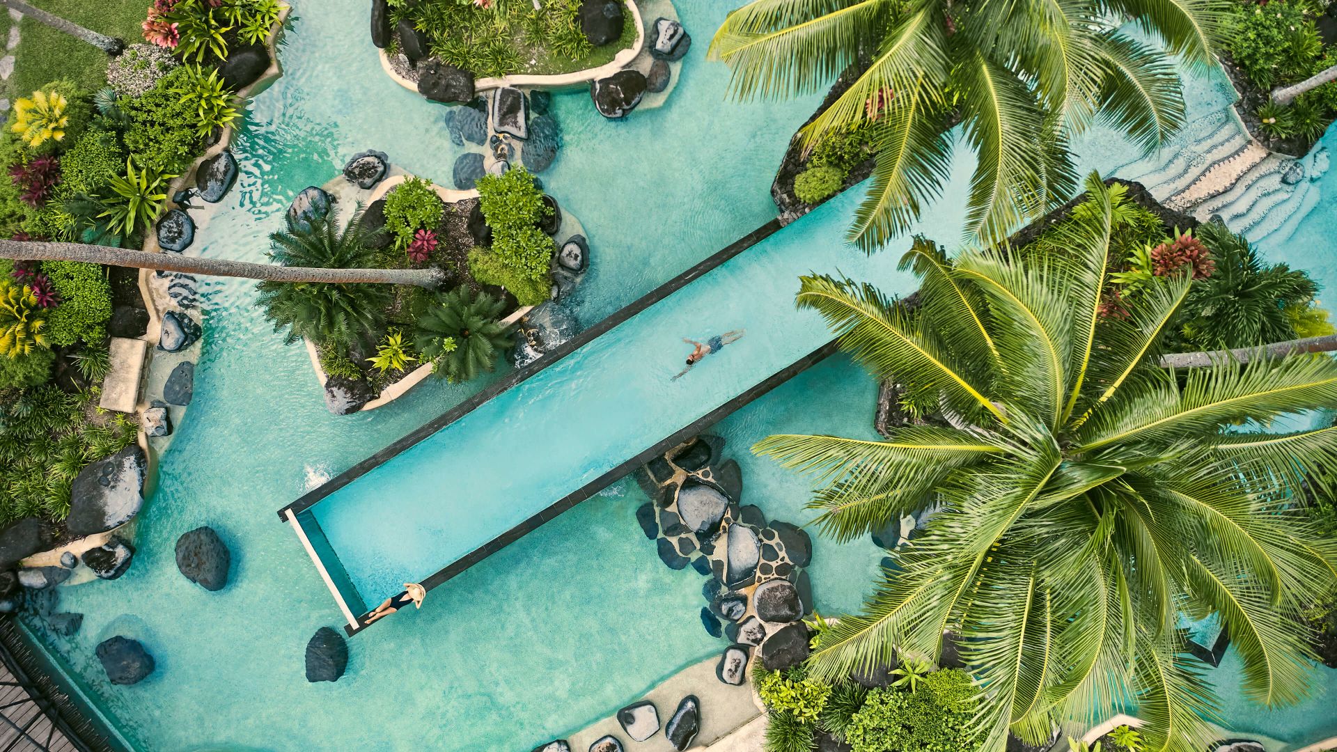 A Pool With A Slide And Trees