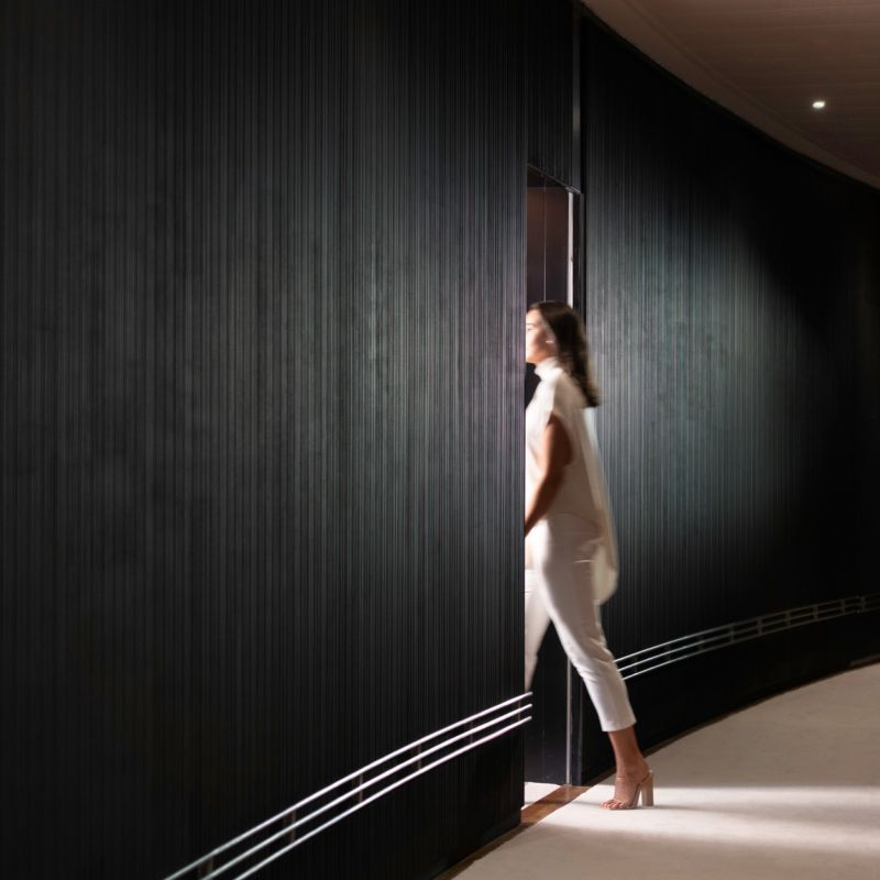 A Woman Walking Down A Hallway Image