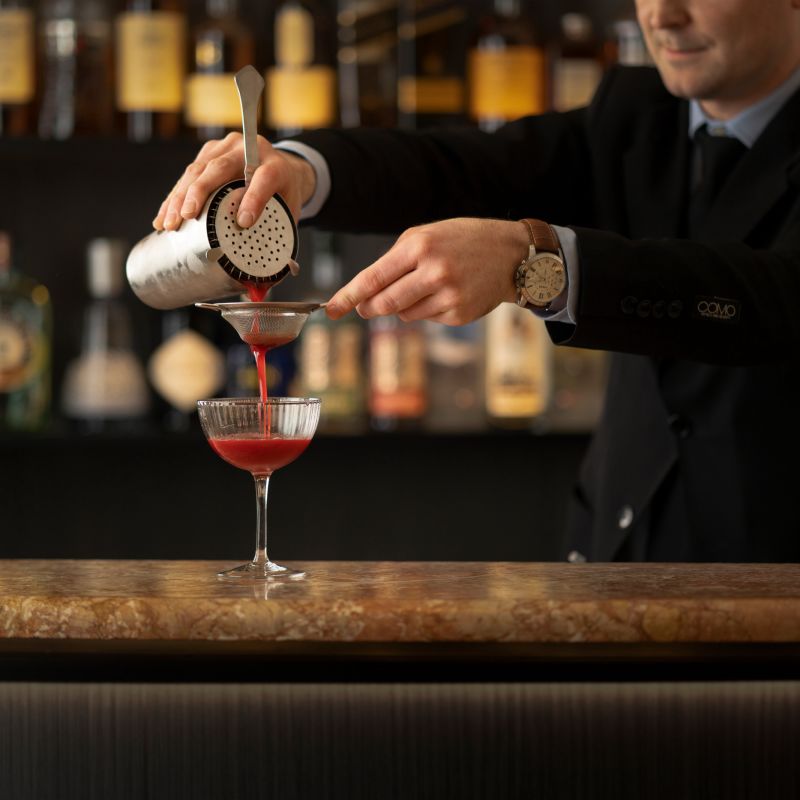 A Person Pouring A Drink Into A Glass Image