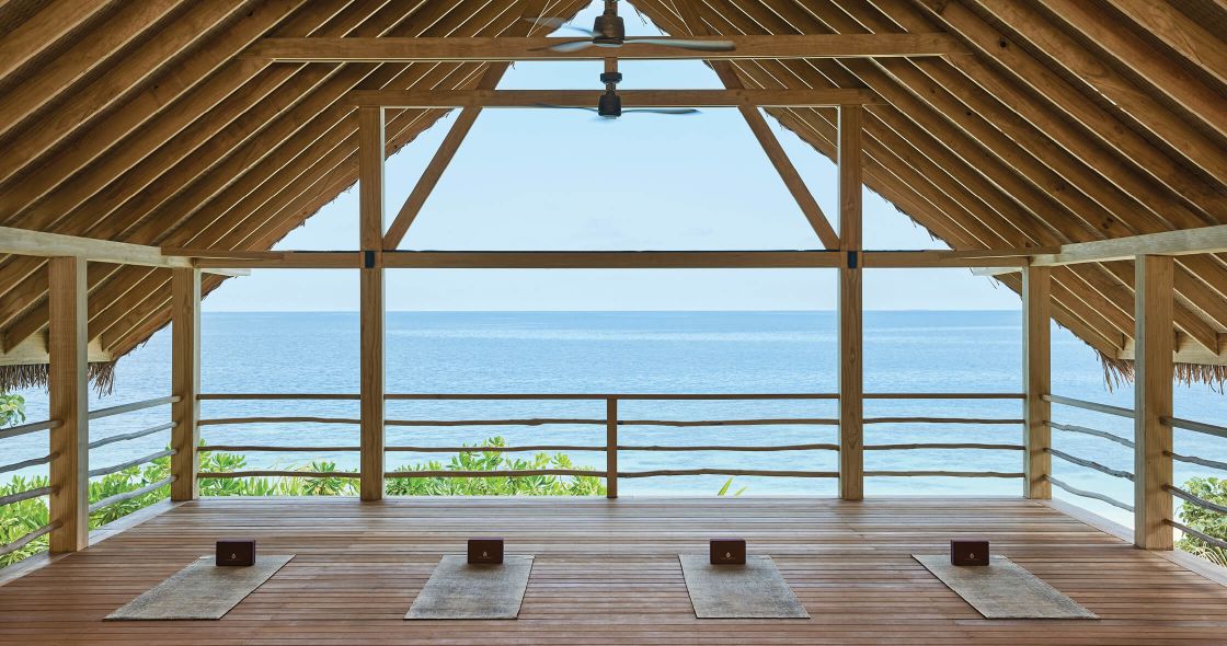 A Wood Deck With A View Of The Ocean And A Beach