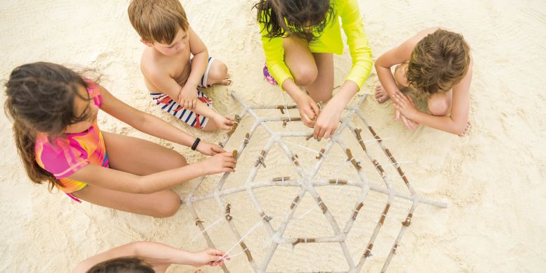 A Group Of Children Playing On A Sand Castle