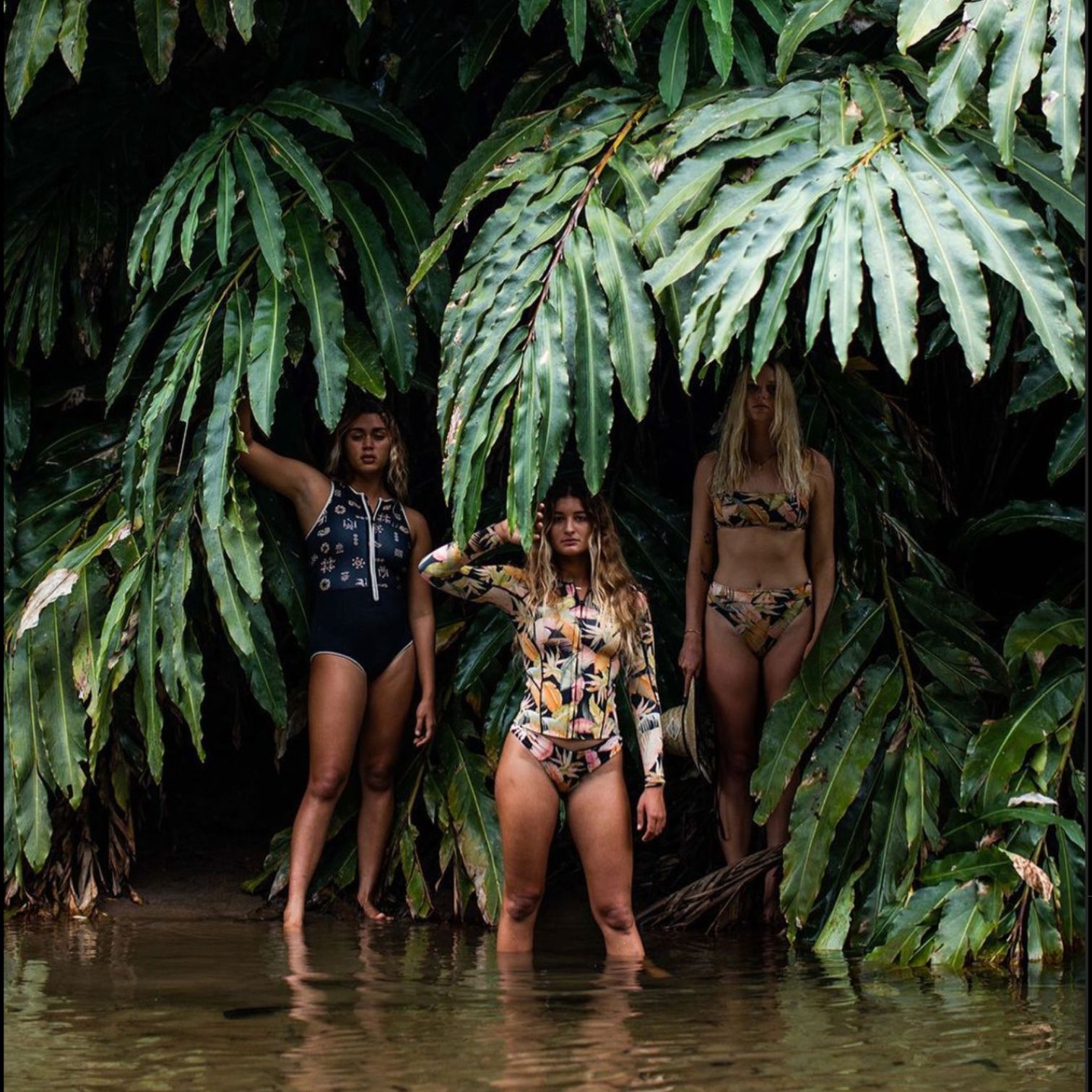 A Group Of Women In Swimsuits Standing In Water