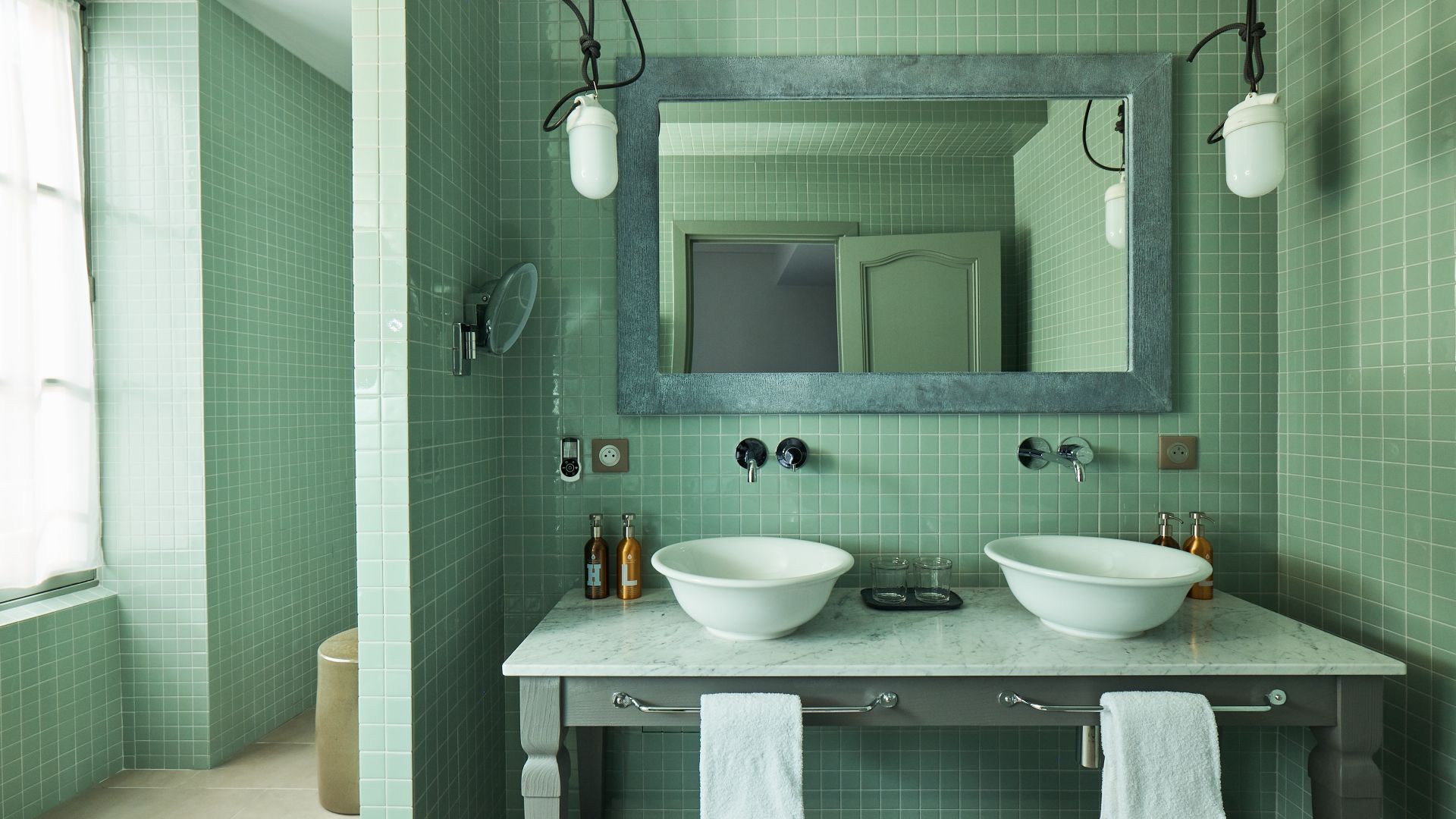 A Bathroom With A Large Mirror - Image