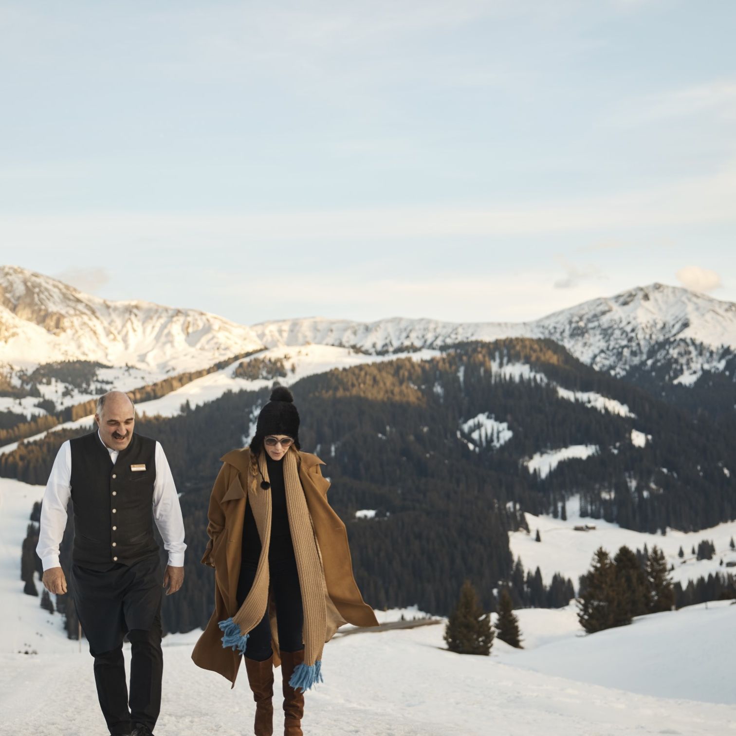 A Man And Woman Standing On A Snowy Mountain