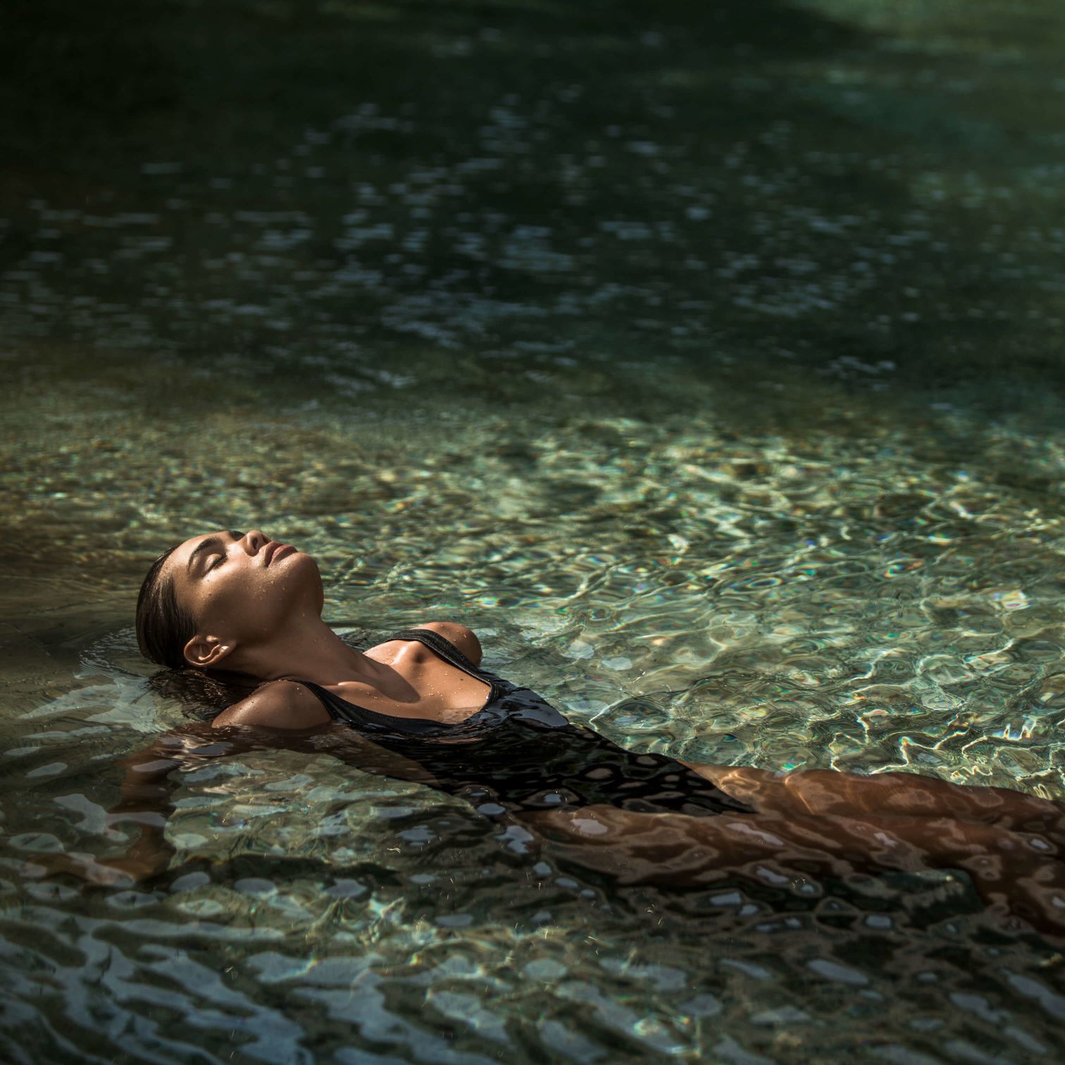 A Person Lying On A Rock In The Water