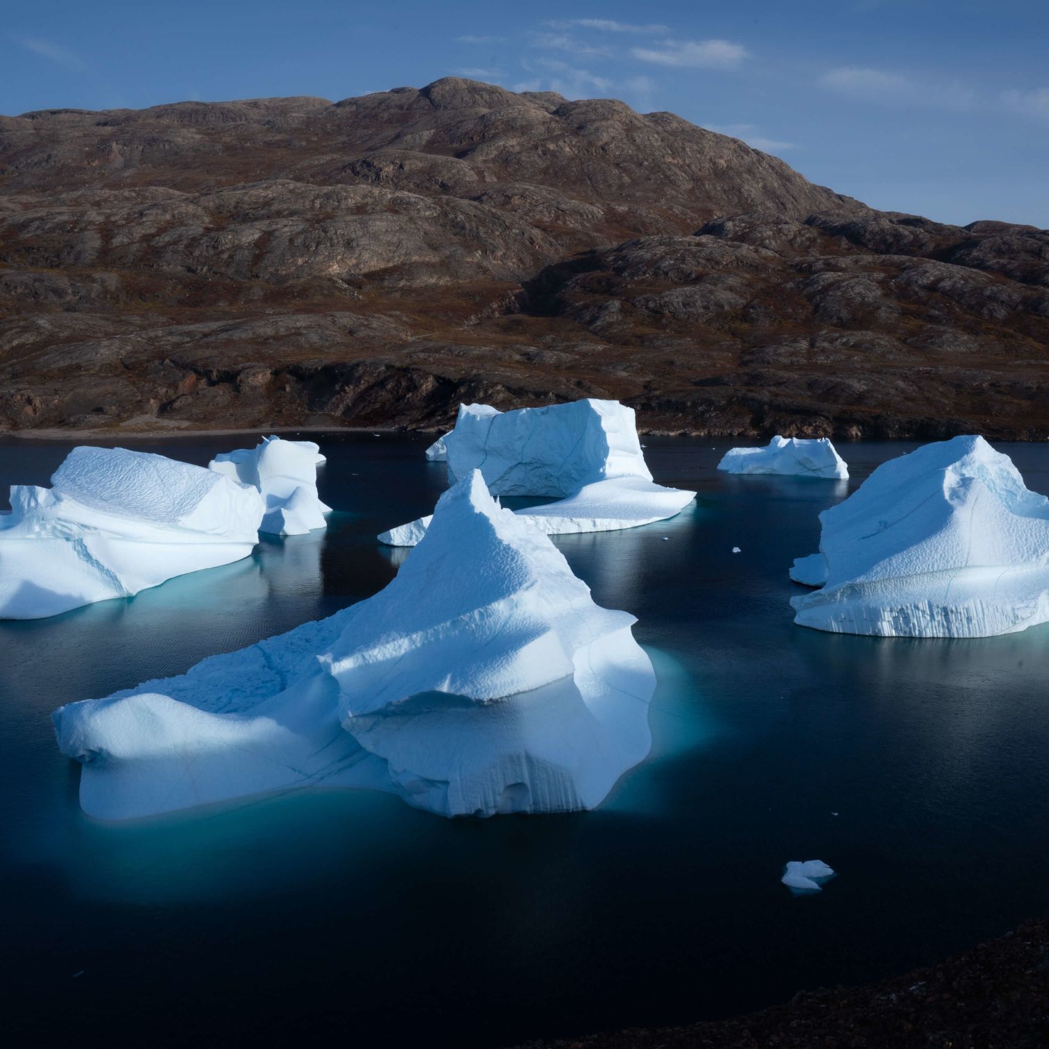 A Group Of Icebergs In A Body Of Water