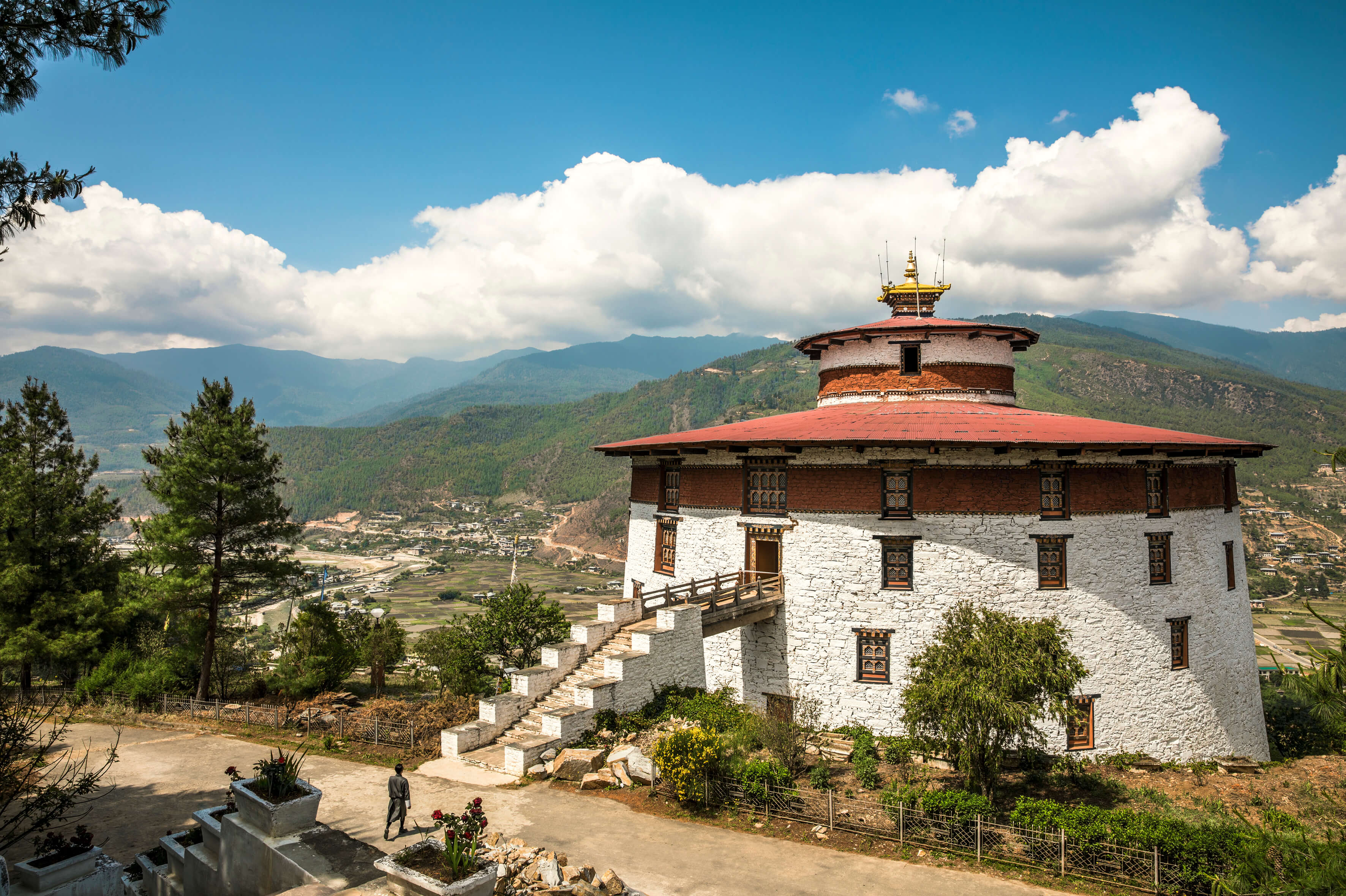 National Museum Of Bhutan With A Red Roof And A Red Roof With A Red Roof And A Person Walking Up