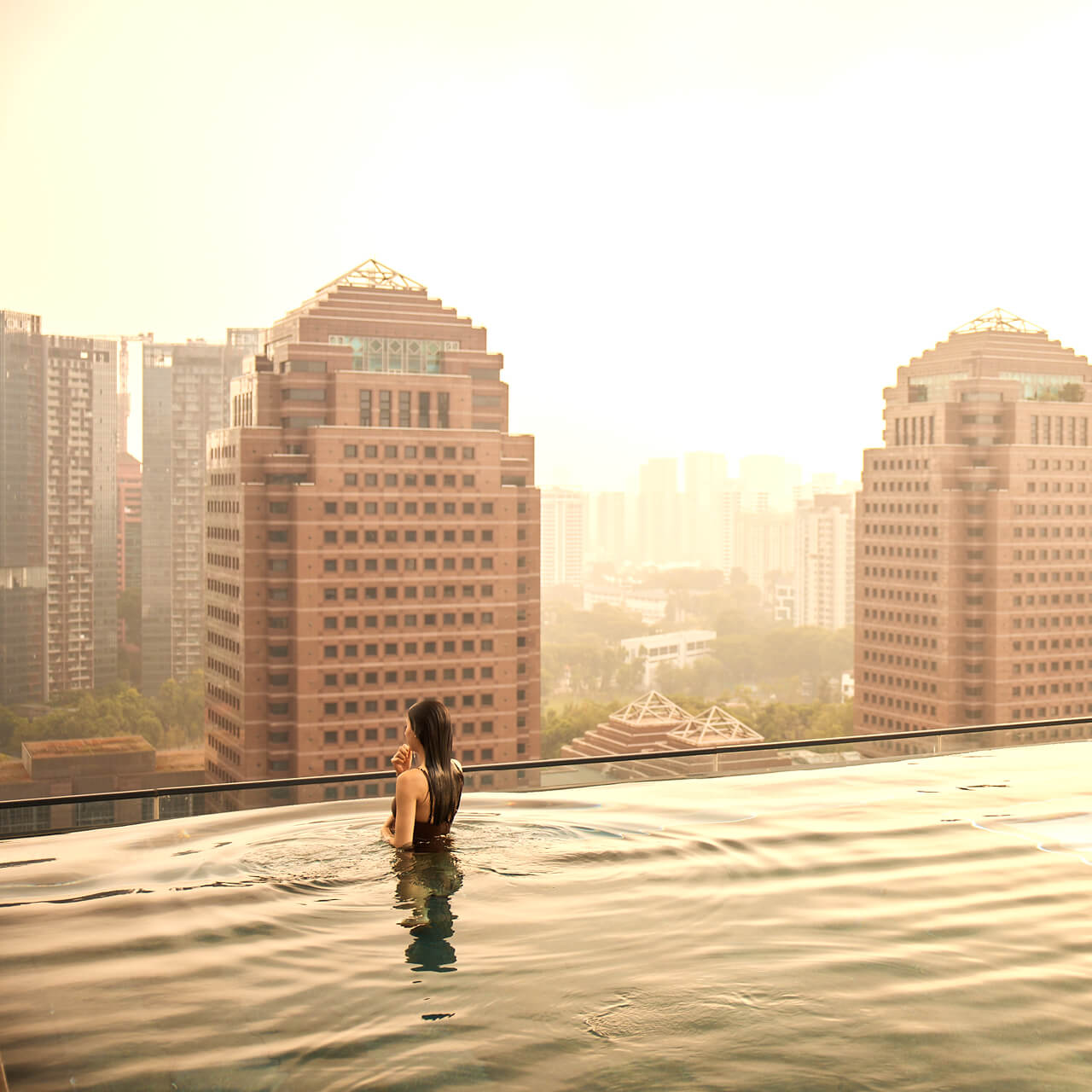 A Person Standing In Water With Buildings In The Background