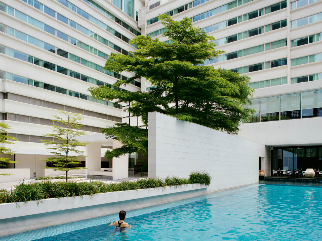 A Person In A Pool By A Building