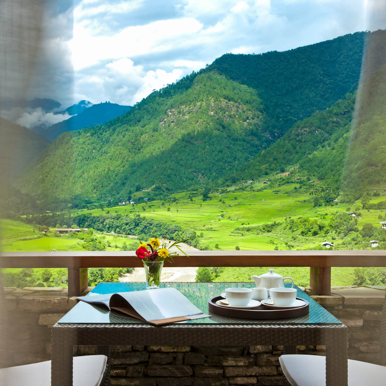 A Table With A Laptop And A Book On It With A Valley In The Background